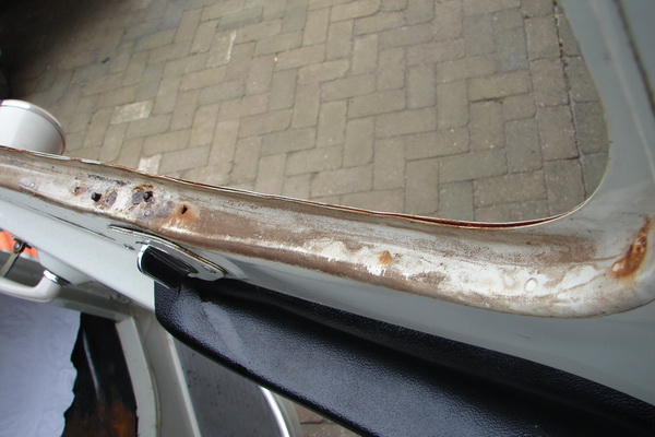 Foto 2: in het middelste deel, onderkant, net naast de vergrendeling.